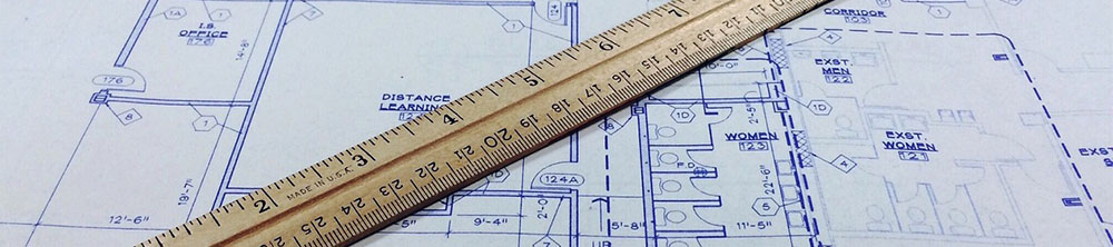 blueprints with a ruler sitting on top of them.
