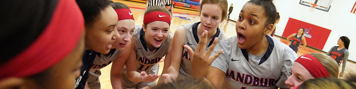 women's basketball team in a huddle before a game.