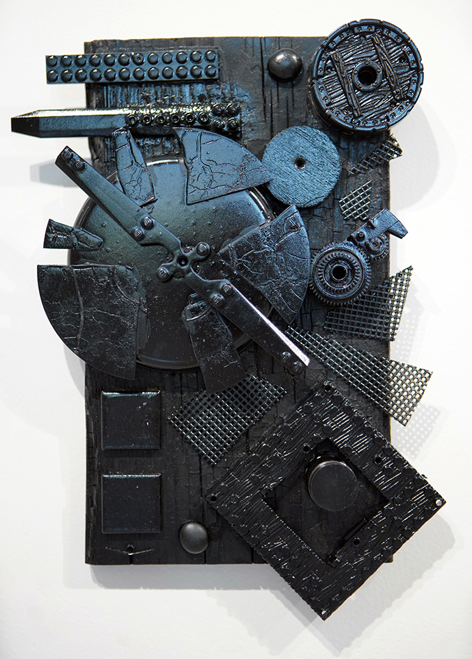 title Clockwork. found object art all painted black that looks like a clock.