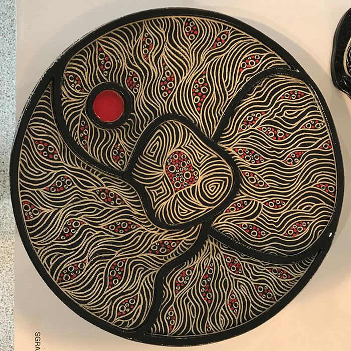 large patter with a carved pattern on black and red.