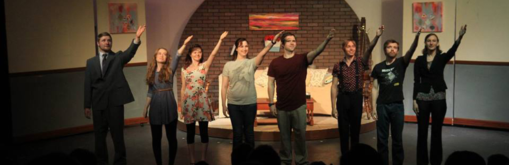 theatre stage with actors arm raised