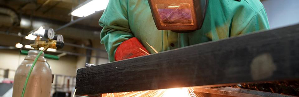 Student welding on a piece of metal.