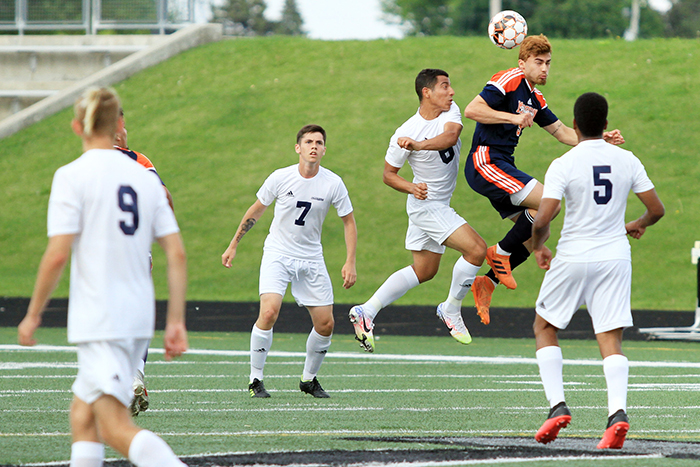 soccer game, two players going for a jump ball.