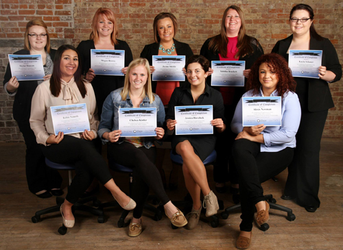 group of cosmetology students holding their certificates