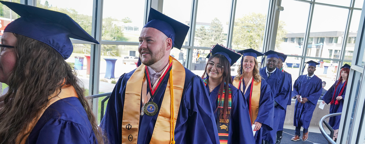 A line of students with cap and gowns on.