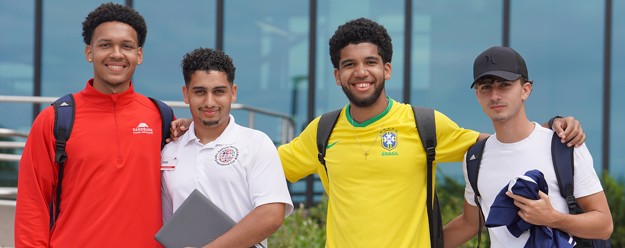Four male students smiling at the camera.
