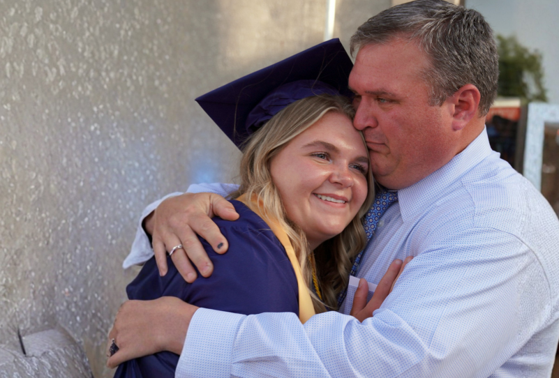 Father hugging his Sandburg graduate