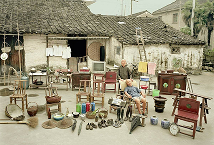 Two old Mongolian men out infront of their home with their furniture, shoes, and electronics.