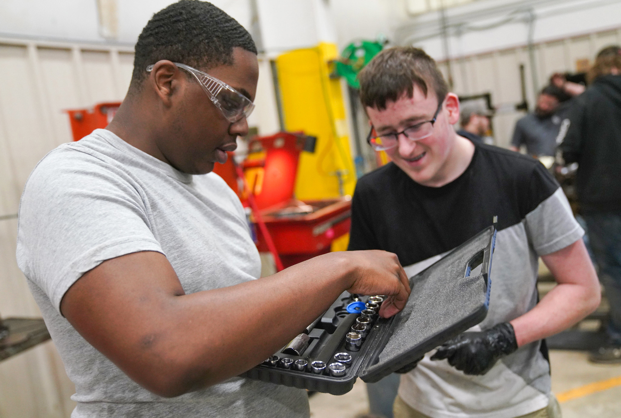 two students getting tools out of a tool kit.