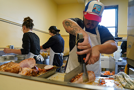 Student slicing a piece of turkey.