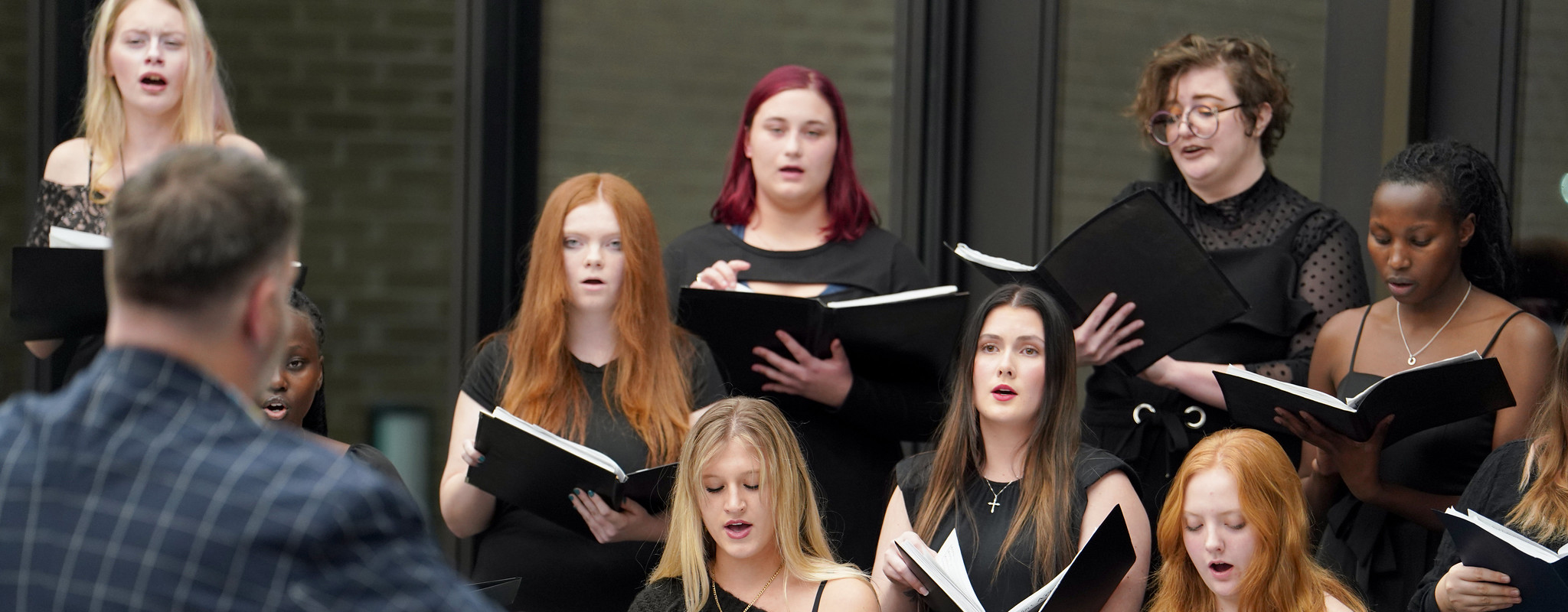 a group of people singing at a concert.