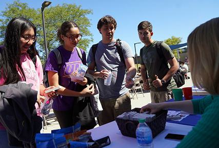 students standing around a table talking.