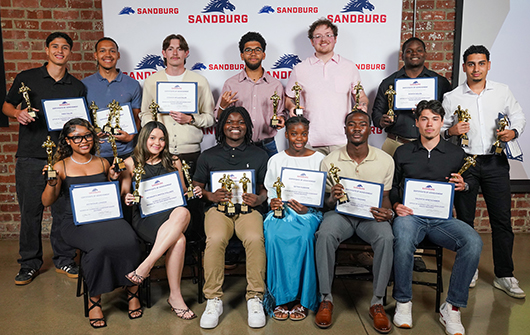 Group of students holding awards at event.
