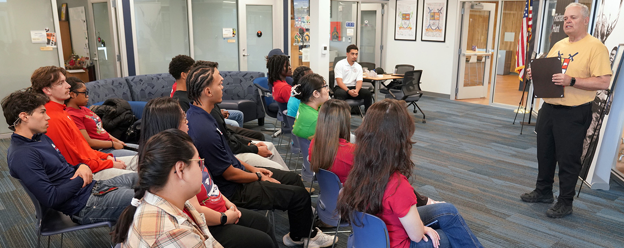 Group sitting in chairs listening to a speaker.