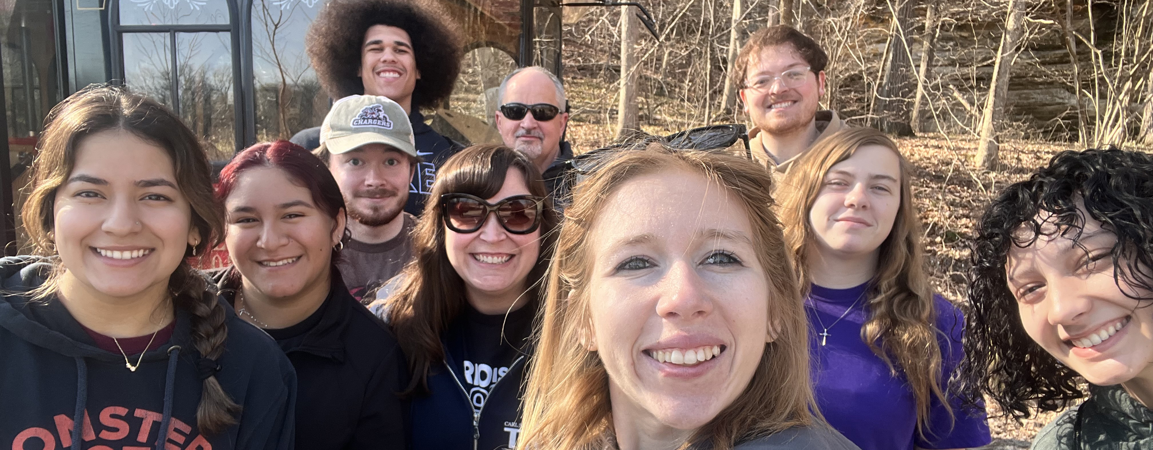 student in a group in the woods.