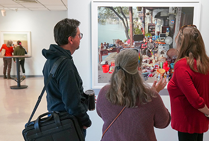 Three people looking at a photo in the gallery.