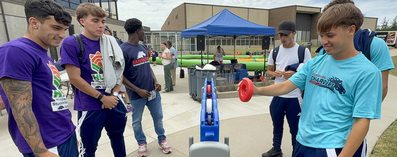 students on patio at spring fest playing connect four.